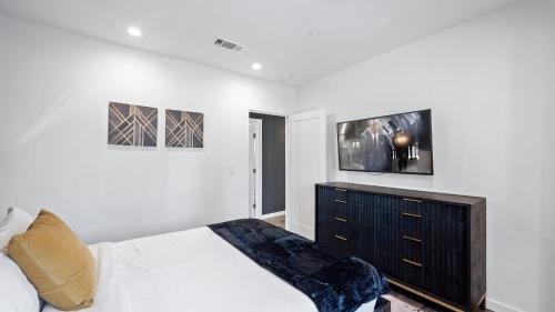 a bedroom with a bed and a tv on the wall at Art Deco by AvantStay 1920s Remodeled Bungalow Open Layout Courtyard in Los Angeles