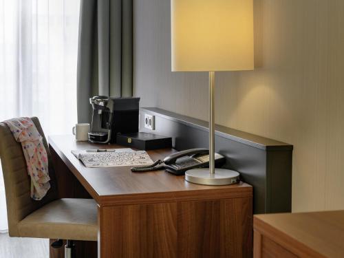 a desk with a lamp on it in a hotel room at Mercure Stuttgart Sindelfingen an der Messe in Sindelfingen