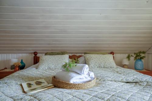 a bed with a basket on it with a book at Frosty Brook Cottage Hosted by Hygge Host in Lehtola