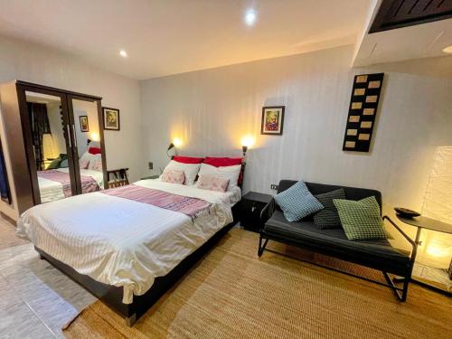 パタヤ・サウスにあるFurnished Studio Near The Beachのベッドルーム1室(ベッド1台、鏡、ソファ付)