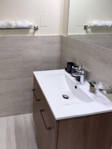 a bathroom with a white sink and a mirror at 2BR Duplex in Masdar 5 Mins to Abu Dhabi Airport in Abu Dhabi