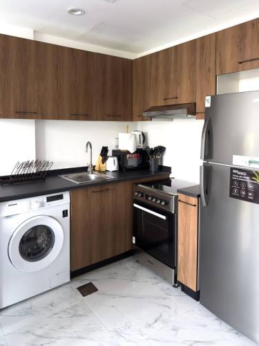 a kitchen with a washing machine and a washer at 2BR Duplex in Masdar 5 Mins to Abu Dhabi Airport in Abu Dhabi