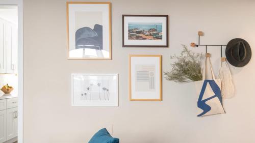 a wall with framed pictures on a white wall at Seashore Suites by AvantStay Modern Comfort Steps from La Jolla Cove in San Diego