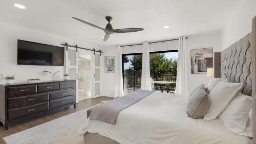 a white bedroom with a large bed and a tv at Paso Vista Bella by AvantStay Luxe Group Escape w Wine Country Views in Paso Robles