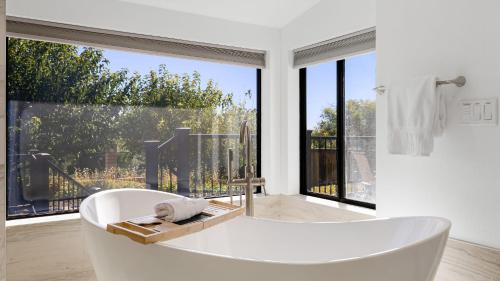 a white bath tub in a room with a large window at Paso Vista Bella by AvantStay Luxe Group Escape w Wine Country Views in Paso Robles