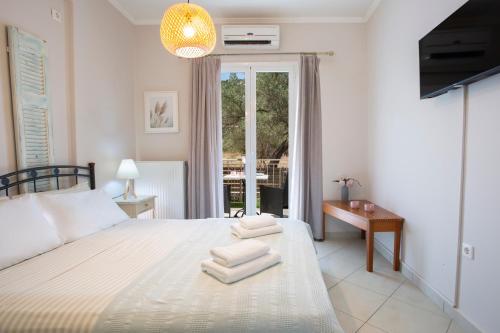 a bedroom with a large bed with towels on it at Levanda Cozy Apartments in Lefkada