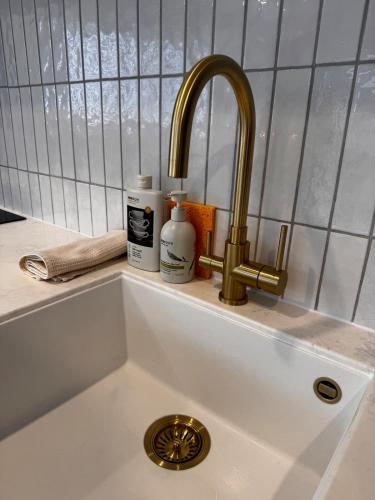 a sink with a faucet and two bottles of soap at Remarkables Escape in Queenstown Airport