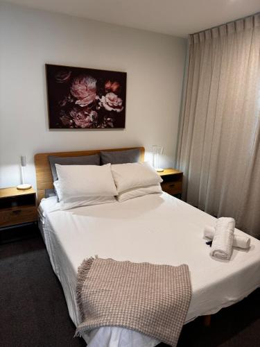 a bedroom with a white bed with two towels on it at Remarkables Escape in Queenstown Airport