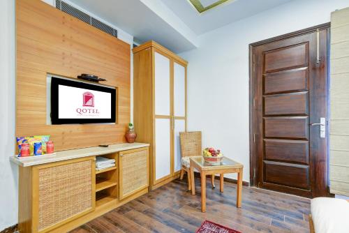 a living room with a television and a table at Qotel Signature Lavish Rajouri Garden New Delhi in New Delhi