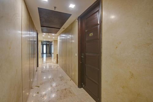 an empty hallway with a wooden door and a hallway at Qotel Signature Lavish Rajouri Garden New Delhi in New Delhi