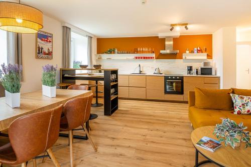a kitchen and living room with a couch and a table at Panorama Spa Lodges DAS.SCHILLER in Bad Gastein