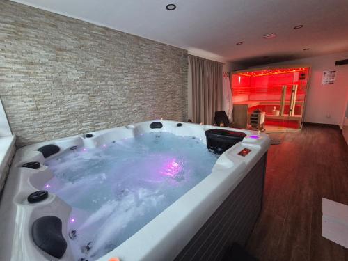 a jacuzzi tub in a room with a brick wall at Apartmani Lara Modruš-Kuća za odmor in Modruš
