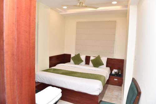 a bedroom with a bed with green pillows at Mertiya Residency in Jodhpur
