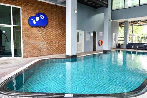 a pool in a building with a cloud sign on the wall at Kokotel Bangkok Dheva Thonglor in Bangkok