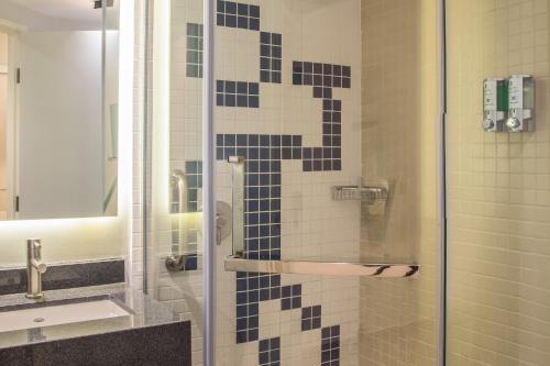 a bathroom with a shower with blue and white tiles at One Coatzacoalcos Forum in Coatzacoalcos
