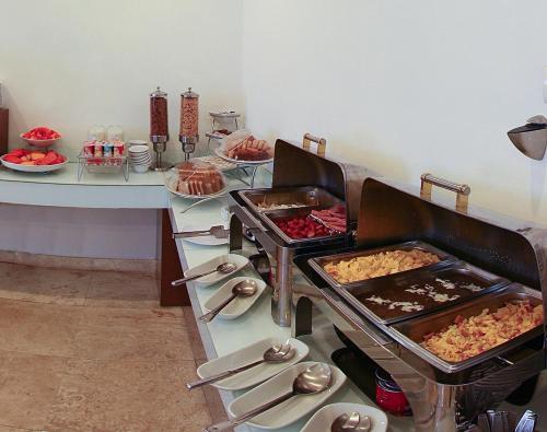a buffet with several trays of food on a table at One Coatzacoalcos Forum in Coatzacoalcos