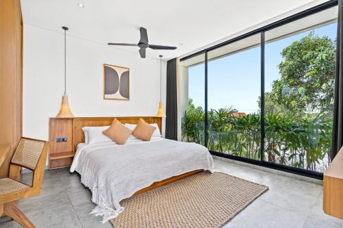 ein Schlafzimmer mit einem Bett und einem großen Fenster in der Unterkunft Modern Villa with Pool - Lago Villas in Bingin Beach