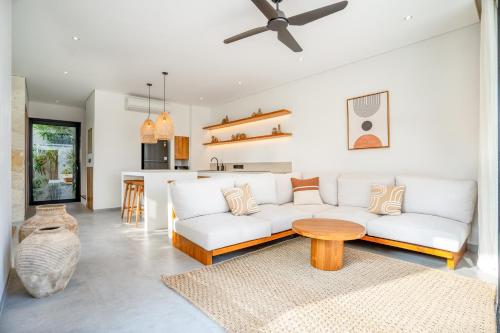 ein Wohnzimmer mit einer weißen Couch und einem Tisch in der Unterkunft Modern Villa with Pool - Lago Villas in Bingin Beach