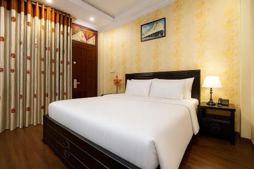 a bedroom with a large white bed in a room at Ha Noi Lake View Hotel & Travel in Hanoi