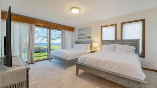 Cette chambre dispose de 2 lits et d'une télévision. dans l'établissement Bay Estate Luxe Waterfront Home w Private Pier, Main and Guest House, Bay Views, à Ridge