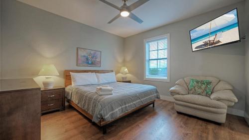 ein Schlafzimmer mit einem Bett und einem Stuhl in der Unterkunft Ridley Retreat Community Pool Mins to the Beach Corpus Christi Port A in Padre Island