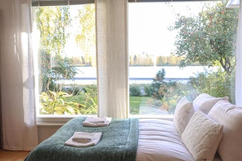 a bed in a room with a large window at Aurora River View 3-Bedroom Apartment by BookLapland in Rovaniemi