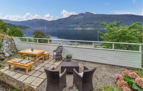 a patio with a table and chairs and a view of a lake at Awesome Home In Eidfjord With House Sea View in Bu