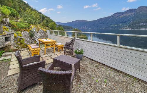 a deck with chairs and a table with a view of the water at Awesome Home In Eidfjord With House Sea View in Bu