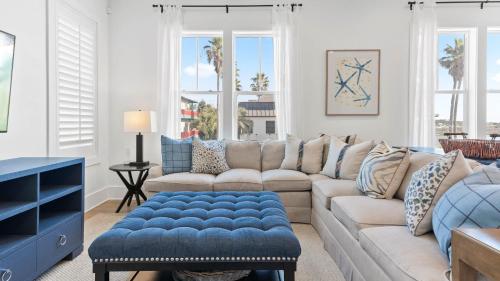 a living room with a couch and a blue ottoman at Grayt Digs by AvantStay Next to Beach Oceanview in Santa Rosa Beach