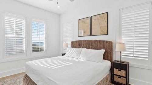 a white bedroom with a bed and two windows at Grayt Digs by AvantStay Next to Beach Oceanview in Santa Rosa Beach