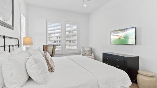 a white bedroom with a white bed and two windows at Grayt Digs by AvantStay Next to Beach Oceanview in Santa Rosa Beach