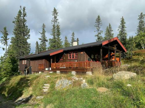 una casa de madera en una colina con árboles en Modern Mountain Cabin With Views Over Slokovannet, en Haglebu