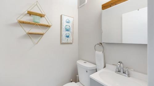 a bathroom with a toilet and a sink and a mirror at California Dreamin by AvantStay Private Pool Fire Pit Near the Beach in Carlsbad