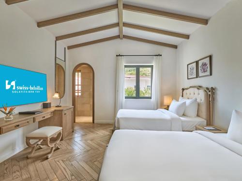a hotel room with two beds and a tv at Swiss-Belvillas Solavita Binh Tien in Binh Tien