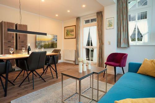 a living room with a blue couch and a table at Ferienwohnung 13 Villa Eden in Binz