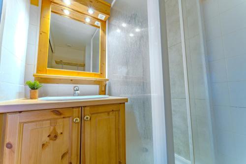 a bathroom with a shower and a sink and a mirror at Hauts de Vanoise 3 personnes Coeur Village in Val Thorens