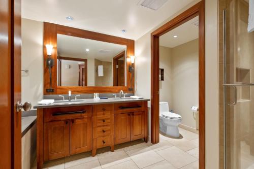 a bathroom with a sink and a toilet and a mirror at Beachfront Condo at Beach Villas at Ko Olina Hale Hoaloha by AvantStay in Honokai Hale