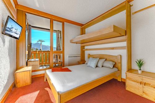 a bedroom with a bunk bed and a balcony at Hauts de Vanoise 3 personnes Coeur Village in Val Thorens