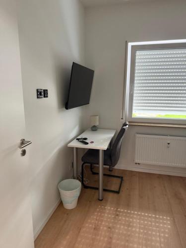 a desk with a chair in a room with a window at Deluxe Apartments Messe Flughafen in Leinfelden-Echterdingen