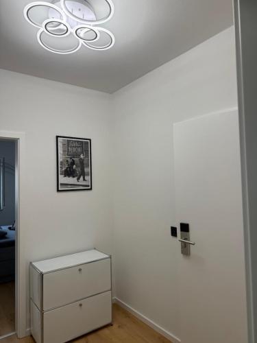 a room with a white wall with a chandelier at Deluxe Apartments Messe Flughafen in Leinfelden-Echterdingen