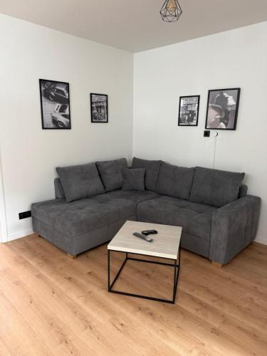a living room with a gray couch and a table at Deluxe Apartments Messe Flughafen in Leinfelden-Echterdingen
