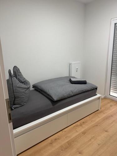 a bed in a room with a white wall at Deluxe Apartments Messe Flughafen in Leinfelden-Echterdingen