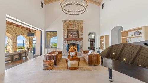 a living room with a fireplace and a piano at Infinity Pool Theater Pickleball 360 Views Near Lake Poway Sunset Point Estate by AvantStay in Rancho Bernardo