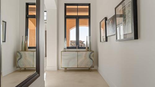 a hallway with a mirror and a table with a window at Infinity Pool Theater Pickleball 360 Views Near Lake Poway Sunset Point Estate by AvantStay in Rancho Bernardo