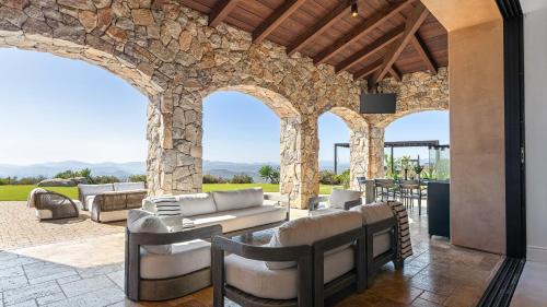an outdoor living room with a stone wall at Infinity Pool Theater Pickleball 360 Views Near Lake Poway Sunset Point Estate by AvantStay in Rancho Bernardo