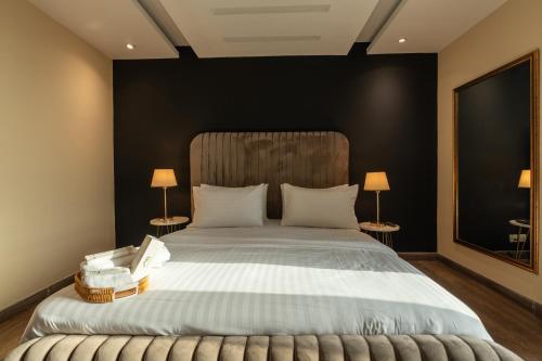 a bedroom with a large bed with two lamps at Gold Crest Luxury Serviced Apartments City View DHA Lahore in Lahore