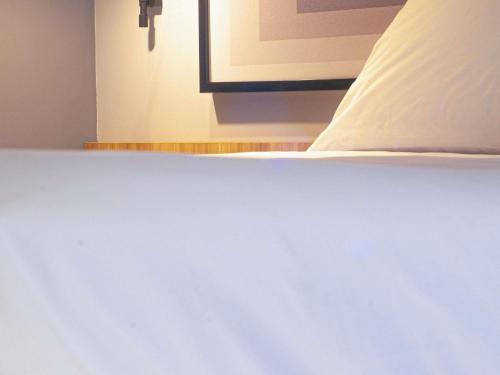 a close up of a white bed with a pillow at Ibis Monterrey Aeropuerto in Monterrey