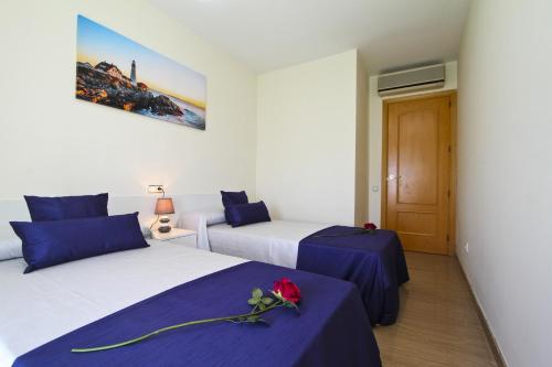 Dos camas en una habitación con azul y blanco. en Apartamento PORTMARINA, en Cambrils