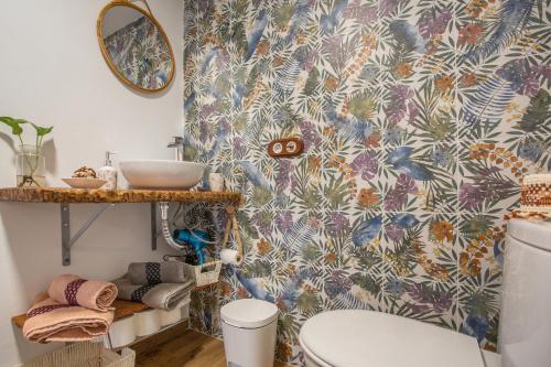 een badkamer met een toilet en behang met vogels bij La Casita Del Cestero in Adelantado