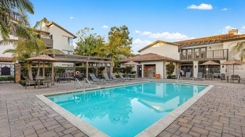 a swimming pool in front of a house at Coastal Retreat w Pool Spa BBQ Near Beaches Golf Courses Ritz Pointe Condo by AvantStay in Dana Point